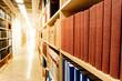 © zephyr_p - Antique leather cover books on wooden bookshelf with aisle perspective in university public library. Reading philosophy or history studying. Education research and self learning concepts
