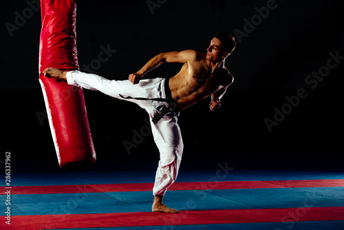 Dekoracja na wymiar  crossfit-fitness-mezczyzna-kick-boxing-z-czerwonym-workiem-treningowym-na-silowni