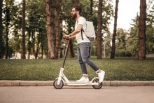 Modern Citizen Traveling By Eco Electric Scooter On Sidewalk