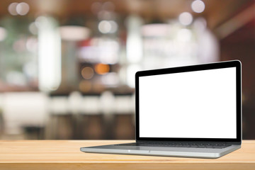 Wall Mural - Blank white screen laptop computer on wood table top with cafe restaurant abstract bokeh light defocused blur background