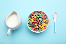 Colorful Corn Rings With Milk In Jar And Spoon On Blue Background