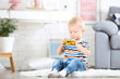 © 5second - Little boy sitting on white carpet at home and playing with car toy