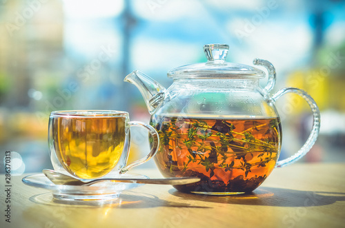 Fotomural A glass teapot with tea and a glass cup with tea stand on the table