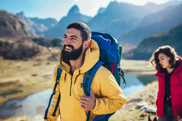 Wall Mural - Couple of hikers walking on a mountain at autumn day.