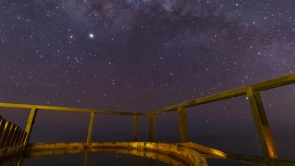 Wall Mural - the milky way galactic core crossing above the sky on a wooden hot tub. amazing view over our univer