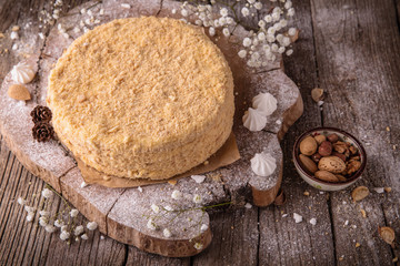 Round multi-layered cake Napoleon with custard, on a  wooden table background. Selective focus