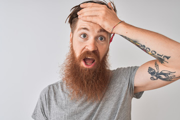 Sticker - Young redhead irish man wearing t-shirt standing over isolated grey background stressed with hand on head, shocked with shame and surprise face, angry and frustrated. Fear and upset for mistake.