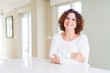 © Krakenimages.com - Beautiful senior woman wearing white sweater at home happy face smiling with crossed arms looking at the camera. Positive person.
