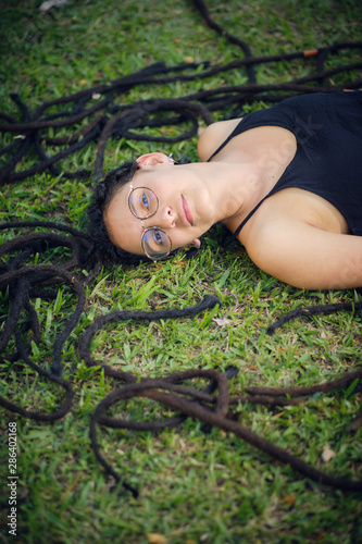 A Girl Lying On A Meadow With Short Hair And Her Dreadlocks Cut