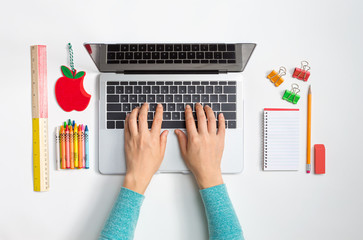 Laptop computer with school supplies from above