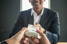 Man Offering Batch Of Hundred Dollar Bills. Hands Close Up. Venality, Bribe, Corruption Concept. Hand Giving Money - United States Dollars (or USD). Hand Receiving Money From Businessman.