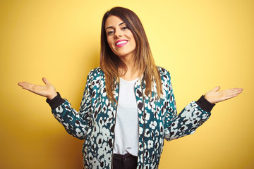 young beautiful woman wearing casual jacket over yellow isolated background smiling showing both han