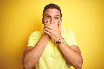 Sticker - Young handsome man wearing casual yellow t-shirt over yellow isolated background shocked covering mouth with hands for mistake. Secret concept.