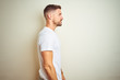 © Krakenimages.com - Young handsome man wearing casual white t-shirt over isolated background looking to side, relax profile pose with natural face and confident smile.