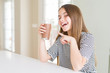 © Krakenimages.com - Beautiful young girl kid drinking fresh tasty chocolate milkshake as snack very happy pointing with hand and finger