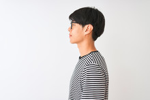 Chinese Man Wearing Glasses And Navy Striped T-shirt Standing Over Isolated White Background Looking To Side, Relax Profile Pose With Natural Face With Confident Smile.