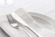 Close up of silverware fork and knife with napkin on the plate.  Restaurant dinning concept.