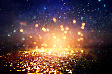 background of abstract glitter lights. blue, gold and black. de focused