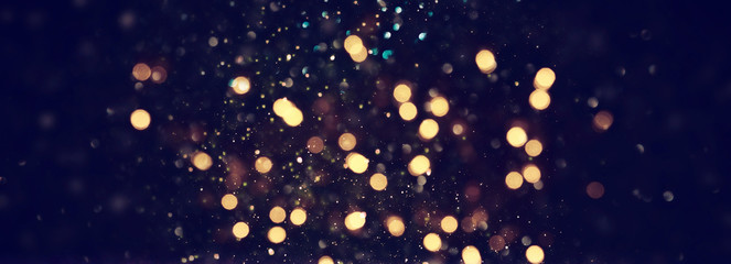 background of abstract glitter lights. blue, gold and black. de focused. banner