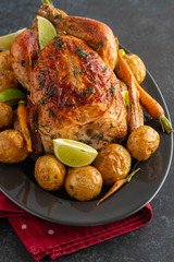 Wall Mural - Roast chicken whole. Served on a plate with vegetables and baked potatoes. Front view.