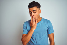 Young Brazilian Man Wearing Blue T-shirt Standing Over Isolated White Background Bored Yawning Tired Covering Mouth With Hand. Restless And Sleepiness.