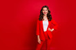 © deagreez - Portrait of elegant lady looking with toothy smile wearing suit isolated over red background