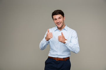 Sticker - Image of cheerful brunette man wearing formal clothes smiling at camera while showing thumbs up