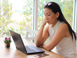 © Phuttharak - Asian woman sit with computer laptop look worried and stressed.