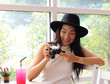 © Phuttharak - Beautiful Asian tourist  weating hat sitting in cafe with camera in her hand