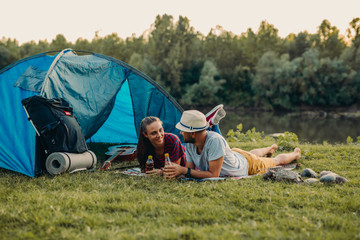 Wall Mural - friends camping by the lake, drinking juice