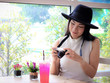 © Phuttharak - Beautiful Asian tourist  weating hat sitting in cafe with camera in her hand