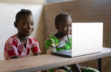 smiling african children working with laptop computer