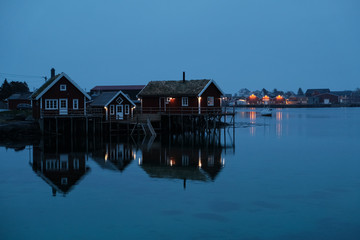 Norway rorbu houses and mountains rocks over fjord landscape scandinavian travel view Lofoten islands. Night landscape.