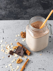 Wall Mural - Glass jar of chocolate coffee milk smoothie cocktail on grey table with copyspace