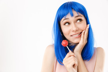 Sticker - Portrait of cute smiling woman wearing blue wig holding lollipop and looking aside at copyspace