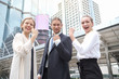 © JuYochi - Group of Business people Success is showing confident and happy after-sales continue to grow while standing outdoors at the walkway in the CBD surrounded by tall buildings.