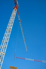 red and white construction tower crane on blue sky