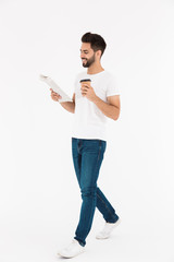 Canvas Print - Full length image of smiling man drinking coffee takeaway and reading newspaper while walking