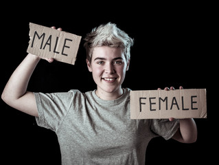 Transgender teenager breaking the word FEMALE into MALE. Gender identity and human rights concept.