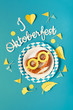 © tilialucida - Paper text 'I love Oktoberfest', pretzel and matching decorations on blue paper