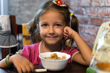 girl child eats at home in the kitchen