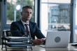 © LIGHTFIELD STUDIOS - selective focus of man sitting near gadgets near document tray in office