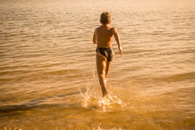 Boy Running On The Water With Splashes