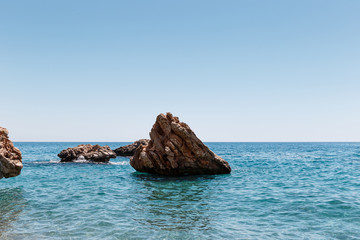 Beautiful seascape. Seascape on the background of the wild rocky coast. Wild beach, azure water and rocks. Luxury summer adventure, Mediterranean sea, Turkey. Postcard view