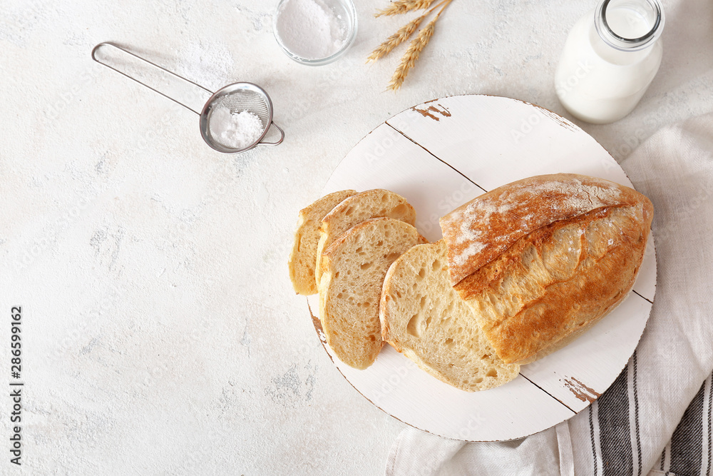 Tasty fresh bread on light background