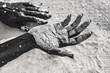 © zolotareva_elina - close up of woman hands painted black on sand. conceptual image
