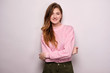 © bestsenny - A girl in a pink sweater stands on a white background, hugging herself with her arms and smiling at the camera.