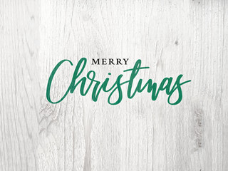 Wall Mural - merry christmas green graphic calligraphy text design with white wood background