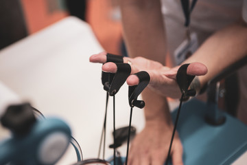 Details with the hand of a woman kinetotherapy medic (physical therapist) showing finger rehabilitation therapy