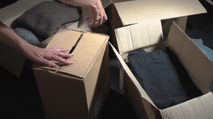 Canvas Print - Woman packing box. Cardboard box with adhesive tape. Donation box